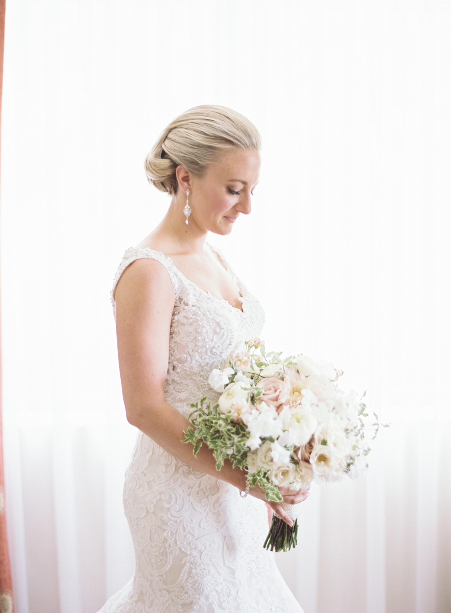 Close up of Allysa and her bouquet by a window