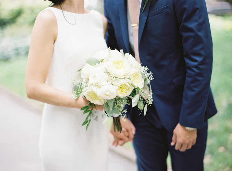 close up film image of bride and groom with white bouquet