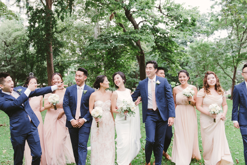bride and groom with bridal party wearing coral dresses and blue suits