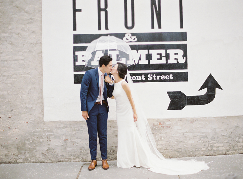 film image of bride and groom in front of the Front and Palmer sign