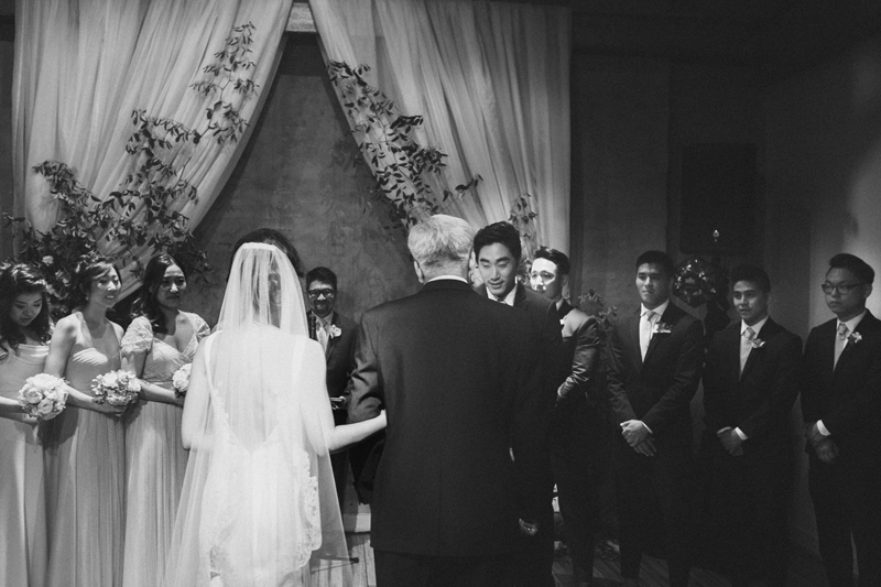 groom greeting brides father at the end of the aisle