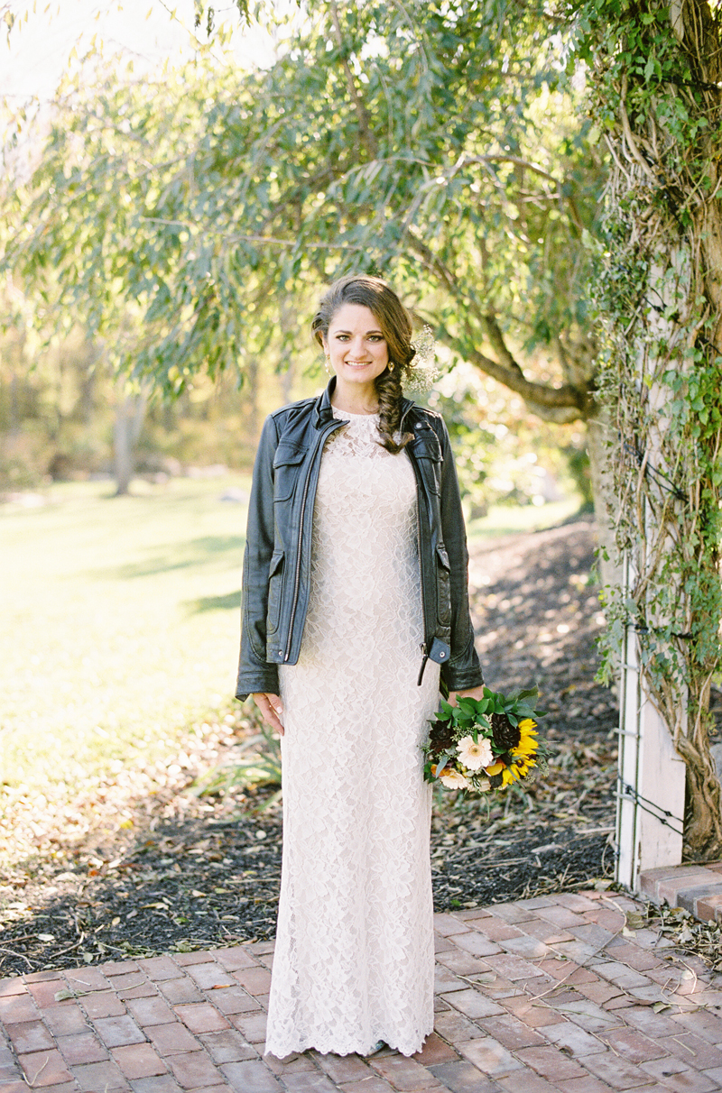 bride wearing lace BHLDN dress with black leather jacket at Brandywine Manor House